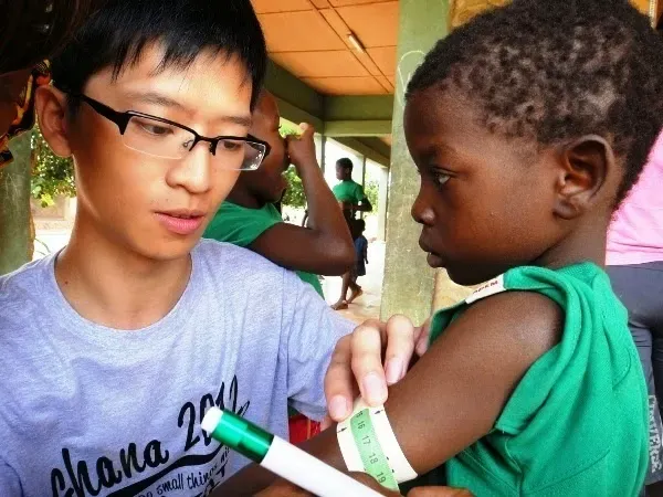A volunteer weighing children on the Moringa nutritional programme — value addition rooted in community